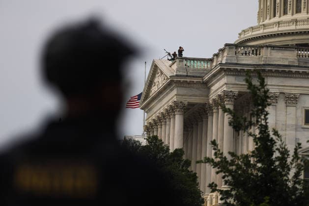 July 28, 2026, Washington, District Of Columbia, USA: Seen beyond a U.S. Capitol Police officer, snipers stand guard on a rooftop at the U.S. Capitol building ahead of a memorial service for U.S. Senator Lindsey Graham (R-SC) in Washington, D.C. on July 28, 2026. Washington USA  - ZUMAd227 20260728_znp_d227_009 Copyright: xBryanxDozierx
