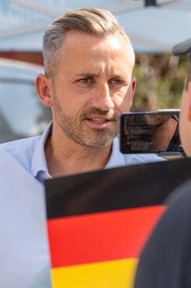Ulrich Siegmund, AfD Spitzenkandidat auf Wahlkampftour in Sachsen-Anhalt, AfD-Infostand in Magdeburg, 28. Juli 2026 Deutschland, Magdeburg, 28. Juli 2026, Ulrich Siegmund, AfD-WSpitzenkandidat bei den Landtagswahlen in Sachsen-Anhalt am 6. September, mit Deutschlandflagge, Wahlkampfstand an der Ecke Goldschmiedebrücke - Breiter Weg, Wahlslogan: Hol dir dein Land zurück, viele Wähler kommen, um ein Selfie mit dem Spitzenkandidaten zu machen, rechtsextreme Landespartei, Politiker, Politik, *** Ulrich Siegmund, AfD lead candidate on the campaign trail in Saxony-Anhalt, AfD information booth in Magdeburg, July 28, 2026 Germany, Magdeburg, July 28, 2026, Ulrich Siegmund, AfD’s top candidate in the state elections in Saxony-Anhalt on September
