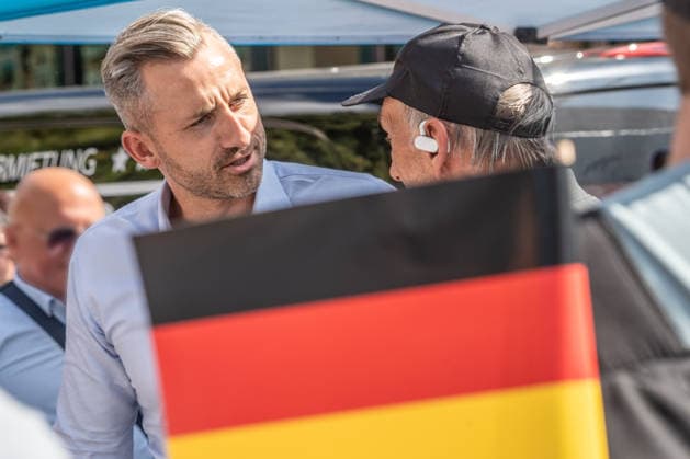 Ulrich Siegmund, AfD Spitzenkandidat auf Wahlkampftour in Sachsen-Anhalt, AfD-Infostand in Magdeburg, im Gespräch mit Wählern, 28. Juli 2026 Deutschland, Magdeburg, 28. Juli 2026, Ulrich Siegmund, AfD-Spitzenkandidat bei den Landtagswahlen in Sachsen-Anhalt am 6. September, im Gespräch mit Wählern, Deutschlandfahne, Wahlkampfstand an der Ecke Goldschmiedebrücke - Breiter Weg, Wahlslogan: Hol dir dein Land zurück, viele Wähler kommen, um ein Selfie mit dem Spitzenkandidaten zu machen, rechtsextreme Landespartei, Politiker, Politik, *** Ulrich Siegmund, AfD lead candidate on the campaign trail in Saxony-Anhalt, at an AfD information booth in Magdeburg, talking with voters, July 28, 2026, Germany, Magdeburg, July 28, 2026, Ulrich Siegmu