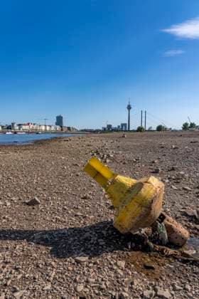 Boje auf Grund, Skyline mit Rheinturm und Rheinkniebrücke, Rhein bei Düsseldorf, extremes Niedrigwasser, Rheinpegel bei 31 cm, Tendenz fallend, nach der langen Dürre fällt das linke Rheinufer, bei Düsseldorf Oberkassel trocken, eine große Sandbank entsteht, Frachtschiffe können nur noch mit deutlich reduzierter Ladung fahren, Skyline der City, Oberkassler Rheinbrücke NRW, Deutschland Niedrigwasser Rhein *** Buoy aground, skyline featuring the Rhine Tower and the Rheinknie Bridge, the Rhine near Düsseldorf, extremely low water levels, Rhine water level at 31 cm, trending downward; following the long drought, the left bank of the Rhine near Düsseldorf-Oberkassel has dried up, a large sandbar has formed, cargo ships can now only sail