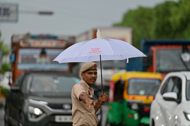 GURUGRAM, INDIA - JULY 28: A traffic police constable manages traffic amid rain at the Sector 14 17 dividing road near MDI Chowk on July 28, 2026 in Gurugram, India. (Photo by Parveen Kumar Hindustan Times) Heavy Rains Inundates Gurugram