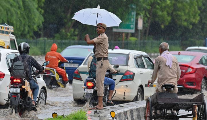 GURUGRAM, INDIA - JULY 28: A traffic police constable manages traffic amid rain at the Sector 14 17 dividing road near MDI Chowk on July 28, 2026 in Gurugram, India. (Photo by Parveen Kumar Hindustan Times) Heavy Rains Inundates Gurugram