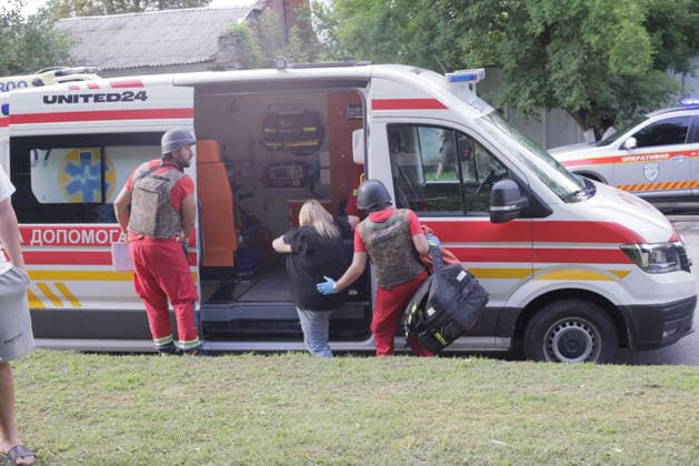 Shahed Drone Strike - Kharkiv Two Ukrainian paramedics wearing ballistic helmets and body armor assist a civilian woman into a United24-marked ambulance following a Russian Shahed drone strike on a five-story residential building in the Novobavarski district of Kharkiv, Ukraine, on July 28, 2026; the drone set the building s roof ablaze, prompting the rapid evacuation of all residents, and at least two people were reported injured. Photo by Titov Yevhen ABACAPRESS.COM Kharkiv Kharkiv Oblast Ukraine  Copyright: xTitovxYevhen ABACAx