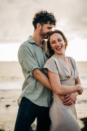 Man lovingly hugging his laughing girlfriend on the beach São Miguel, Açores, Portugal CR_FKNH260728-2086855-01 ,model released, Symbolfoto ,property released