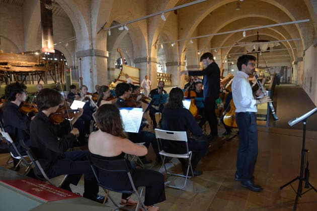 IPA87087020 - Pisa, July 29, 2026 The music and dance series continues at the National Museums of Pisa. At the National Museum of Ancient Ships, Homage to Mozart by the Orchestra da Camera Fiorentina, featuring soloists Barsali and Del Vecchio. In the photo: from left, Del Vecchio on the clarinet and, immediately behind him, Barsali conducting the orchestra.  Copyright: xRobertoCappellox xRobertoxCappellox 87087020