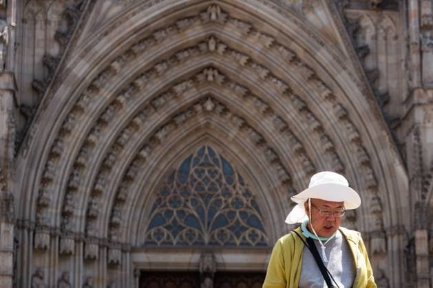 July 29, 2026, Barcelona, ES: BARCELONA, SPAIN - JULY 29, 2026. An Asian tourist walks in front of Barcelona Cathedral, wearing a hat for protection against sunburn, on the first day of the summer s fourth heatwave in Spain. Local authorities have issued high-temperature alerts across Catalonia, urging residents and visitors to take precautions against extreme heat expected to last throughout the week. Barcelona ES  - ZUMAq101 20260729_zna_q101_105 Copyright: xMarcxAsensioxClupesx
