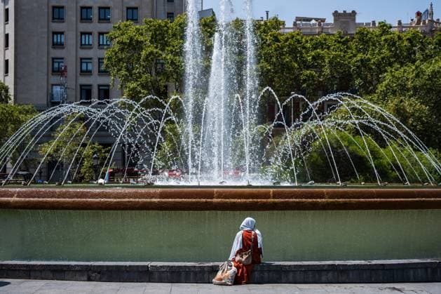 July 29, 2026, Barcelona, ES: BARCELONA, SPAIN - JULY 29, 2026. A woman sits in front of one of the fountains in Plaza Catalunya on the first day of the summer s fourth heatwave in Spain. Local authorities have issued high-temperature alerts across Catalonia, urging residents and visitors to take precautions against extreme heat expected to last throughout the week. Barcelona ES  - ZUMAq101 20260729_zna_q101_106 Copyright: xMarcxAsensioxClupesx