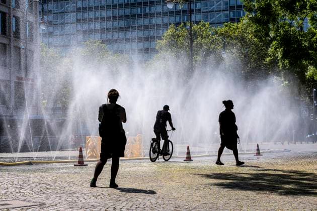 Cooling Cologne, Aktion der Stadt Köln zur Abkühlung von Hitzebelasteten Plätzen, hier der Rudolfplatz in der Innenstadt, bei knapp 37Â°C an dem Tag, ein Sprühschlauch verspritzt feine Wassertröpfen, die die unmittelbare Umgebung einige Grade abkühlt, eine Aktion die bei extremer Hitzebelastung vorgenommen wird, zur Anpassung des Stadtklimas an den Klimawandel, Passanten genießen den kühlenden Moment, dazu gibts Tipps zum Umgang mit Extremhitze, NRW, Deutschland, Extremhitze *** Cooling Cologne, a City of Cologne initiative to cool down areas affected by heat, here at Rudolfplatz in the city center, with temperatures nearing 37°C that day, a spray hose disperses fine droplets of water that cool the immediate surroundings by a few de