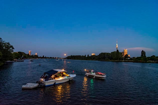 oxbow lake Alte Donau (Old Danube), full moon rise, high-rises at Donaucity, tower Donauturm, boats Vienna 22. Donaustadt Wien Austria