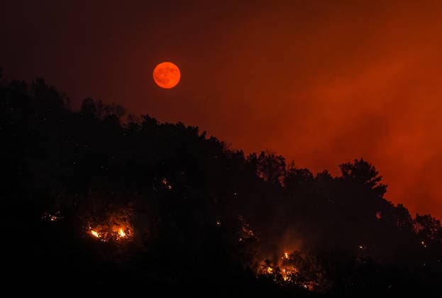 Firefighting efforts continue in Turkiye s Balikesir BALIKESIR, TURKIYE - JULY 29: The full moon appears red due to the flames illuminating the night as smoke from the fire area fills the sky while firefighters and Turkish General Directorate of Forestry teams continue their efforts to extinguish the fire that broke out in the forest area from air and land during the night in Gomec district of Balikesir, Turkiye on July 29, 2026. Sergen Sezgin Anadolu Balikesir Turkey. Editorial use only. Please get in touch for any other usage.  Copyright: x2026xAnadoluxSergenxSezginx