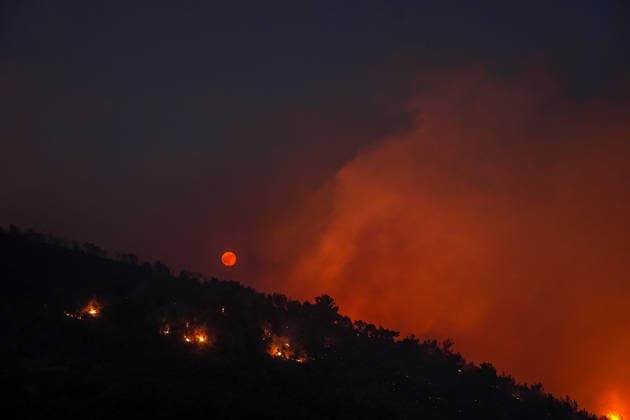 Firefighting efforts continue in Turkiye s Balikesir BALIKESIR, TURKIYE - JULY 29: The full moon appears red due to the flames illuminating the night as smoke from the fire area fills the sky while firefighters and Turkish General Directorate of Forestry teams continue their efforts to extinguish the fire that broke out in the forest area from air and land during the night in Gomec district of Balikesir, Turkiye on July 29, 2026. Sergen Sezgin Anadolu Balikesir Turkey. Editorial use only. Please get in touch for any other usage.  Copyright: x2026xAnadoluxSergenxSezginx