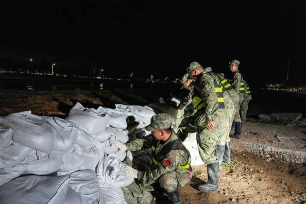 (260730) -- DUNHUANG, July 30, 2026 -- Militiamen stack sandbags to fortify the embankment along the Danghe River in Dunhuang, northwest China s Gansu Province, July 29, 2026. The water level of the Danghe River, which runs through Dunhuang City in northwest China s Gansu Province, rose rapidly following days of heavy rainfall and increased inflows from upstream. Local personnel in Dunhuang quickly mobilized for flood control and relief operations. ) CHINA-GANSU-DUNHUANG-FLOOD CONTROL (CN) LangxBingbing 
