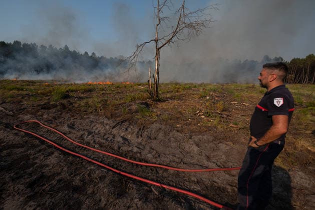 Wildfire Near Le Temple - Gironde A firefighter is seen during wildfire suppression operations near Le Temple, Gironde, southwestern France, on July 29, 2026. Smoke and flames are visible in the background as firefighting efforts continue.  Copyright: xSaptexFabrice ABACAx
