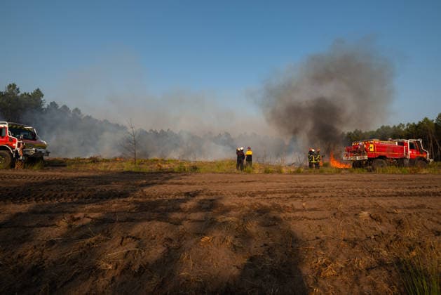 Wildfire Near Le Temple - Gironde Firefighters and fire engines operate across an active wildfire scene near Le Temple, Gironde, southwestern France, on July 29, 2026. Thick smoke rises above burned vegetation as crews work to contain remaining flames and secure the fire perimeter.  Copyright: xSaptexFabrice ABACAx