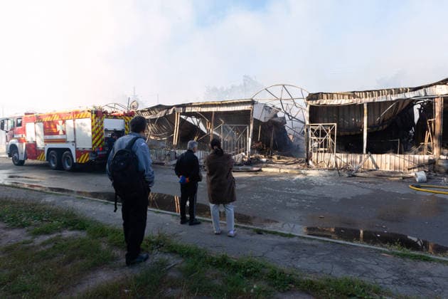 People look at the charred stalls of the Antykar market in Obolonskyi district, which caught fire following an overnight Russian missile strike, Kyiv, Ukraine, July 30, 2026. Debris fell on the market near the Pochaina metro station, igniting trading pavilions. The blaze covered an area of about 100 square metres. Traders’ goods were destroyed, leaving only burnt-out metal structures at the site. (Photo by Kyrylo Chubotin Ukrinform) Market in Kyiv catches fire due to overnight Russian attack  Copyright: xKyryloxChubotinx