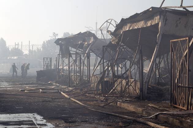 Three people walk past the charred stalls of the Antykar market in Obolonskyi district, which caught fire following an overnight Russian missile strike, Kyiv, Ukraine, July 30, 2026. Debris fell on the market near the Pochaina metro station, igniting trading pavilions. The blaze covered an area of about 100 square metres. Traders’ goods were destroyed, leaving only burnt-out metal structures at the site. (Photo by Kyrylo Chubotin Ukrinform) Market in Kyiv catches fire due to overnight Russian attack  Copyright: xKyryloxChubotinx