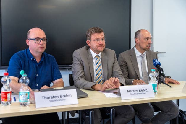 Stadtspitze der Stadt Nürnberg informiert über sofortige Haushaltssperre, Nürnberg, 30.07.2026 Pressekonferenz zur Haushaltssperre der Stadt Nürnberg: Stadtkämmerer Thorsten Brehm (links) blickt nachdenklich, Oberbürgermeister Marcus König (Mitte) spricht konzentriert und gestikulierend, während 2. Bürgermeister Andreas Krieglstein (rechts) mit ernster Miene zuhört. Mikrofone lokaler Sender stehen auf dem Tisch. Nürnberg Bayern Deutschland *** Nuremberg City Leaders Announce Immediate Budget Freeze, Nuremberg, July 30, 2026 Press conference on the City of Nuremberg’s budget freeze: City Treasurer Thorsten Brehm (left) looks pensive, Mayor Marcus König (center) speaks intently and gesticulates, while Deputy Mayor Andreas Krieglst 20260730-1V9A6487-M4000
