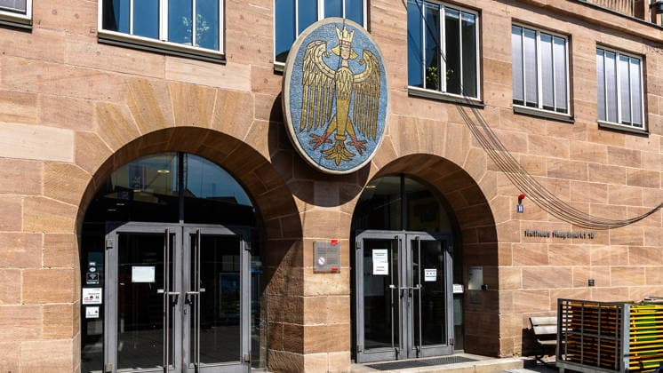 Stadtspitze der Stadt Nürnberg informiert über sofortige Haushaltssperre, Nürnberg, 30.07.2026 Eingangsbereich des Rathauses am Hauptmarkt 18. Über den Rundbogenportalen ist das Wappen des Oberbürgermeisters als vergoldetes Mosaik-Medaillon an der Sandsteinfassade angebracht. Nürnberg Bayern Deutschland *** Nuremberg City Leaders Announce Immediate Budget Freeze, Nuremberg, July 30, 2026 Entrance area of City Hall at Hauptmarkt 18 Above the arched portals, the mayor’s coat of arms is mounted on the sandstone facade as a gilded mosaic medallion Nuremberg Bavaria Germany 20260730-1V9A6543-M4000