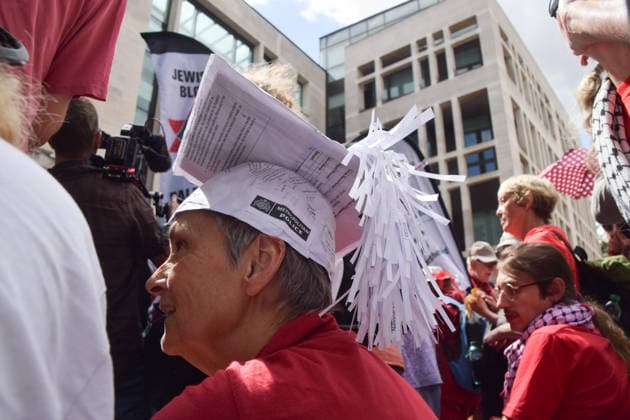 July 30, 2026, London, England, United Kingdom: A protester wears a graduation cap made out of Met Police arrest documents outside Westminster Magistrates Court during the so-called Graduation Day protest organised by Defend Our Juries. Police reportedly made arrests on unspecified charges as well as alleged support for the activist group Palestine Action, which is proscribed in the UK. London United Kingdom - ZUMAv130 20260730_zip_v130_017 Copyright: xVukxValcicx