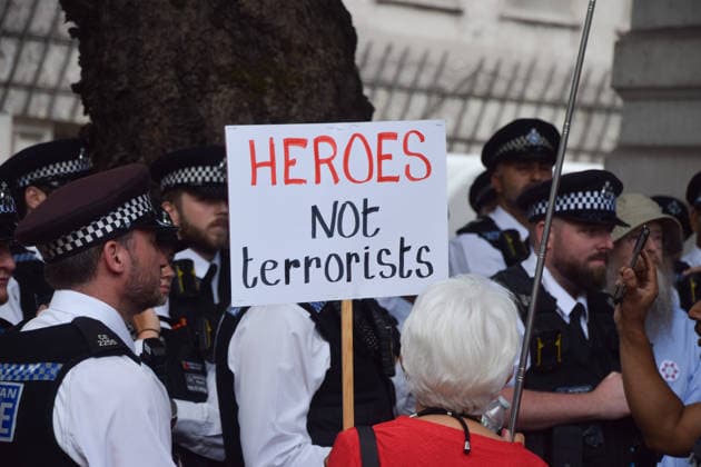July 30, 2026, London, England, United Kingdom: A protester holds a Heroes not terrorists sign while police officers make arrests as pro-Palestine protesters gather outside Westminster Magistrates Court during the so-called Graduation Day protest organised by Defend Our Juries. Police reportedly made arrests on unspecified charges as well as alleged support for the activist group Palestine Action, which is proscribed in the UK. London United Kingdom  - ZUMAv130 20260730_zip_v130_019 Copyright: xVukxValcicx