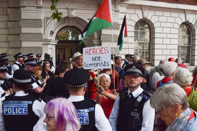 July 30, 2026, London, England, United Kingdom: A protester holds a Heroes not terrorists sign while police officers make arrests as pro-Palestine protesters gather outside Westminster Magistrates Court during the so-called Graduation Day protest organised by Defend Our Juries. Police reportedly made arrests on unspecified charges as well as alleged support for the activist group Palestine Action, which is proscribed in the UK. London United Kingdom - ZUMAv130 20260730_zip_v130_021 Copyright: xVukxValcicx