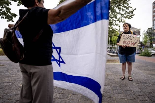 ROTTERDAM - A woman with an Israeli flag and a pro-Palestinian activist precede the commemoration of the deportation of Jewish Rotterdammers during the Second World War. In Rotterdam, deportations began in 1942 from Warehouse 24 in the port area. The occupiers used that location as a gathering place where Dutch Jews were brought together. ROBIN VAN LONKHUIJSEN ANP netherlands out - belgium out  Copyright: xx x564582718x originalFilename: 564582718.jpg