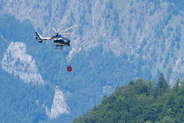 Firefighters battle mountain wildfire near Oberwössen in Bavaria. Germany - Oberwössen, 30.07.2026 Firefighters battle a mountain wildfire above Oberwössen in the Traunstein district of Bavaria on Thursday. Ground crews, supported by police helicopters carrying out bambi buckets, work to contain the blaze in steep and difficult-to-access terrain. Bavaria
