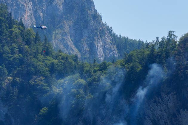 Firefighters battle mountain wildfire near Oberwössen in Bavaria. Germany - Oberwössen, 30.07.2026 Firefighters battle a mountain wildfire above Oberwössen in the Traunstein district of Bavaria on Thursday. Ground crews, supported by police helicopters carrying out bambi buckets, work to contain the blaze in steep and difficult-to-access terrain. Bavaria