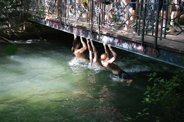 Munich residents ride trams in swimwear after cooling off in Eisbach, a summer routine in the city MUNICH, GERMANY - JULY 30: Young men hold onto a bridge against the strong current while cooling off in the Eisbach river at the Englischer Garten as record hot weather affects the city, in Munich, Germany, on July 30, 2026. Munich records its hottest July 30 since 1947. Merve Goettl Anadolu Munich Germany. Editorial use only. Please get in touch for any other usage.  Copyright: x2026xAnadoluxMervexGoettlx