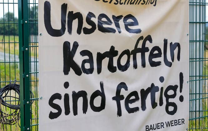 News Bilder des Tages 31.07.2026, Deutschland, NRW, Landwirtschaft, Hofläden, Unsere Kartoffeln sind fertig steht auf einem Bauernhof-Banner, Kartoffelernte, Deutschland *** July 31, 2026, Germany, North Rhine-Westphalia, Agriculture, Farm Stores, Our potatoes are ready reads a banner at a farm, Potato harvest, Germany Copyright: xD.xKerlekin SnowfieldxPhotographyx SF310726KartoffelnD