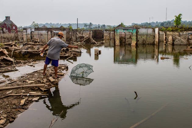 July 31, 2026, Lebak Regency, Banten, Indonesia: A man casts a fishing net as he walks through the ruins of Somang village, which has re-emerged as water levels recede during the dry season, amid forecasts that El NioÂ±o may contribute to drier-than-normal conditions, at Karian Reservoir in Sajira district, Lebak Regency, Banten province, Indonesia, July 31, 2026. Lebak Regency Indonesia  - ZUMAp283 20260731_zip_p283_015 Copyright: xClaudioxPramanax