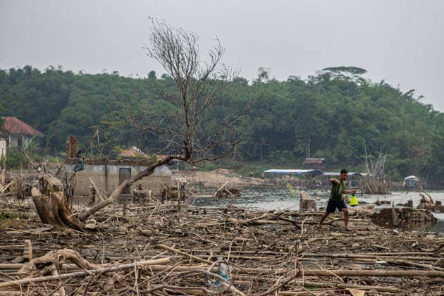 July 31, 2026, Lebak Regency, Banten, Indonesia: A man carries a fishing net as he walks through the ruins of Somang village, which has re-emerged as water levels recede during the dry season, amid forecasts that El NioÂ±o may contribute to drier-than-normal conditions, at Karian Reservoir in Sajira district, Lebak Regency, Banten province, Indonesia, July 31, 2026. Lebak Regency Indonesia  - ZUMAp283 20260731_zip_p283_019 Copyright: xClaudioxPramanax