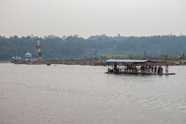 July 31, 2026, Lebak Regency, Banten, Indonesia: A bamboo raft carrying tourists passes through the ruins of Somang village, which have re-emerged as water levels recede during the dry season, amid forecasts that El NioÂ±o may contribute to drier-than-normal conditions, at Karian Reservoir in Sajira district, Lebak Regency, Banten province, Indonesia, July 31, 2026. Lebak Regency Indonesia  - ZUMAp283 20260731_zip_p283_022 Copyright: xClaudioxPramanax