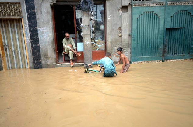 July 31, 2026, Peshawar, Peshawar, Pakistan: Residents wade through flooded street as monsoon rains inundate Peshawar..People wade through a flooded street during heavy monsoon rain in Peshawar, Khyber Pakhtunkhwa province, Pakistan, on July 31, 2026. Pakistan s Meteorological Department (PMD) forecast the current monsoon spell to continue until August 5, warning of widespread rain, thunderstorms, heavy to very heavy downpours, and the risk of urban flooding, flash floods, landslides and river flooding across parts of the country. Peshawar Pakistan  - ZUMAa217 20260731_znp_a217_020 Copyright: xHussainxAlix