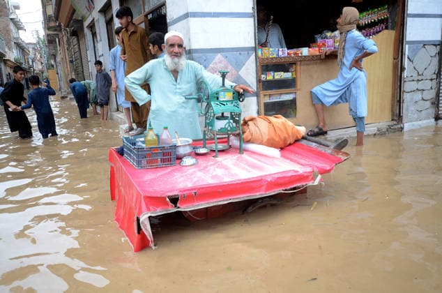 July 31, 2026, Peshawar, Peshawar, Pakistan: Residents wade through flooded street as monsoon rains inundate Peshawar..People wade through a flooded street during heavy monsoon rain in Peshawar, Khyber Pakhtunkhwa province, Pakistan, on July 31, 2026. Pakistan s Meteorological Department (PMD) forecast the current monsoon spell to continue until August 5, warning of widespread rain, thunderstorms, heavy to very heavy downpours, and the risk of urban flooding, flash floods, landslides and river flooding across parts of the country. Peshawar Pakistan - ZUMAa217 20260731_znp_a217_029 Copyright: xHussainxAlix