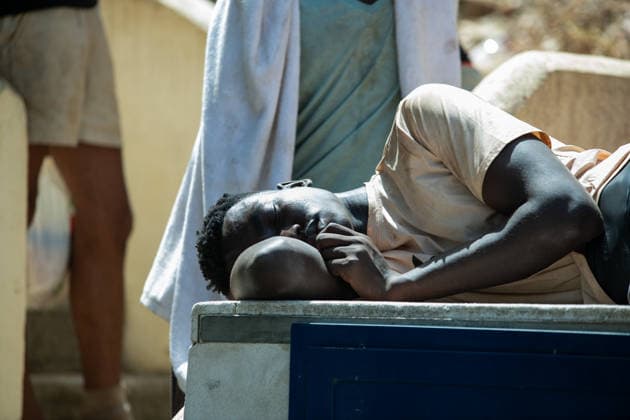 August 1, 2026, Ceuta, Spain: A man sleeps on a bench outside the The Ceuta Temporary Immigrant Stay Center (CETI). CETI is currently facing extreme tension and severe overcrowding, reaching a state of absolute collapse. The facility has been forced to close its doors to new male arrivals due to a critical lack of space. Ceuta Spain  - ZUMAd308 20260801_zsp_d308_048 Copyright: xJuanxCarlosxLucasx