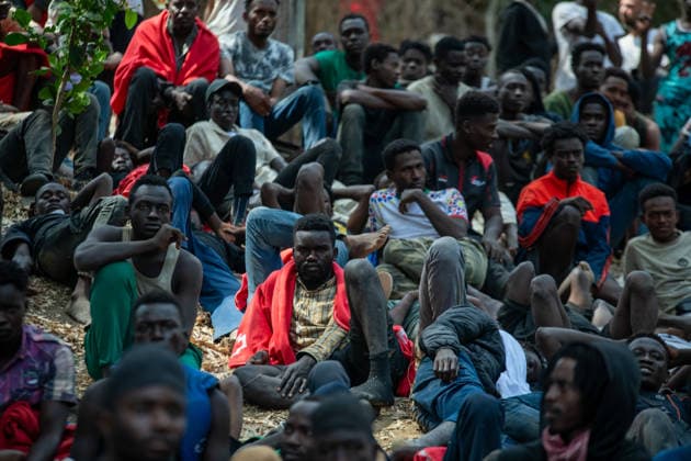August 1, 2026, Ceuta, Spain: Crowds of men sit outside the The Ceuta Temporary Immigrant Stay Center (CETI). CETI is currently facing extreme tension and severe overcrowding, reaching a state of absolute collapse. The facility has been forced to close its doors to new male arrivals due to a critical lack of space. Ceuta Spain - ZUMAd308 20260801_zsp_d308_012 Copyright: xJuanxCarlosxLucasx