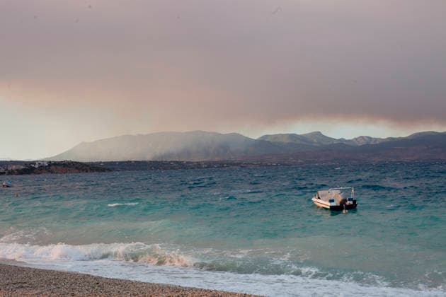 Wildfire Smoke and Strong Winds Hit Corinthia Coast A boat rests on the shore as waves break along the coast beneath a sky filled with wildfire smoke in Almiri, Corinthia, Greece on August 1, 2026. Strong winds generate rough sea conditions and carry smoke across the Saronic Gulf from a wildfire burning in the neighboring regional unit of Viotia, where firefighters continue efforts to contain the blaze. Almiri Corinthia Greece Copyright: xElvisxTakahashixMantellox