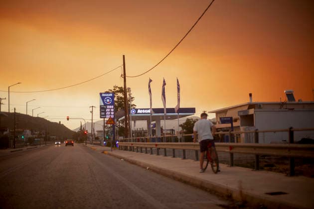 Wildfire Smoke and Strong Winds Hit Corinthia Coast A person rides a bicycle beneath a sky filled with wildfire smoke in Almiri, Corinthia, Greece on August 1, 2026. Smoke from a wildfire burning in the neighboring regional unit of Viotia spreads across the Saronic Gulf as firefighters continue efforts to contain the blaze. Almiri Corinthia Greece Copyright: xElvisxTakahashixMantellox