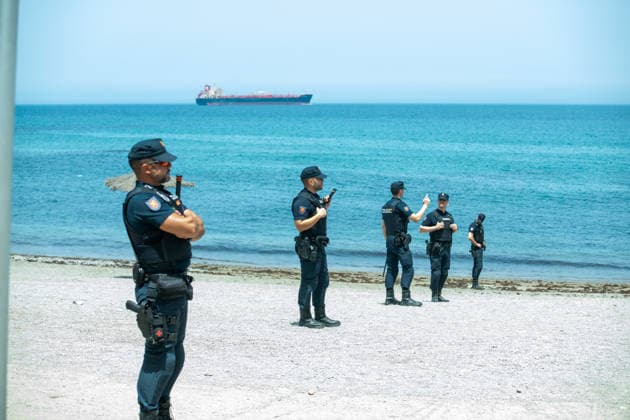 August 1, 2026, Ceuta, Ceuta, Spain: Spanish National Police officers stand around a large group of migrants near the Temporary Stay Centre for Immigrants Ceuta Spain - ZUMAd308 20260801_zsp_d308_079 Copyright: xJuanxCarlosxLucasx