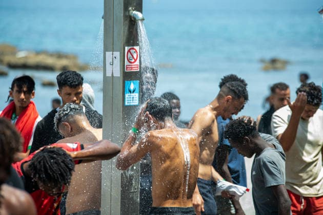 August 1, 2026, Ceuta, Ceuta, Spain: A group of migrants use beach showers near the Temporary Stay Centre for Immigrants Ceuta Spain - ZUMAd308 20260801_zsp_d308_081 Copyright: xJuanxCarlosxLucasx