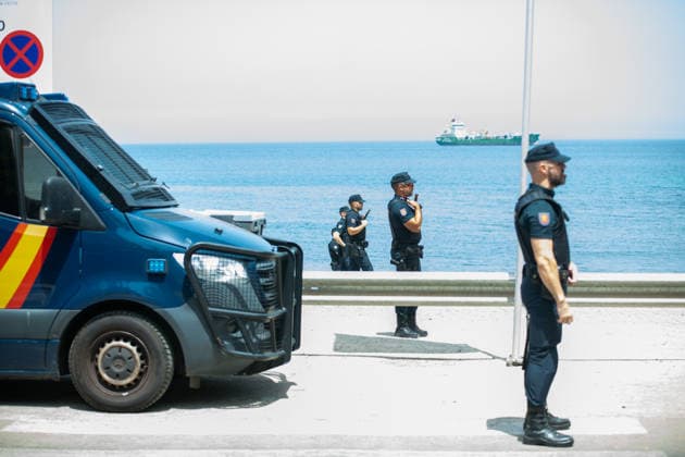 August 1, 2026, Ceuta, Ceuta, Spain: Spanish National Police officers stand around a large group of migrants near the Temporary Stay Centre for Immigrants Ceuta Spain - ZUMAd308 20260801_zsp_d308_088 Copyright: xJuanxCarlosxLucasx