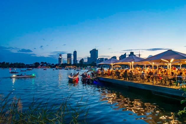 Lichterlfest (Lichterfest, Festival of Lights) at oxbow lake Alte Donau (Old Danube), illuminated boats, high-rises of Donaucity, floating restaurant Strandcafe Vienna 22. Donaustadt Wien Austria