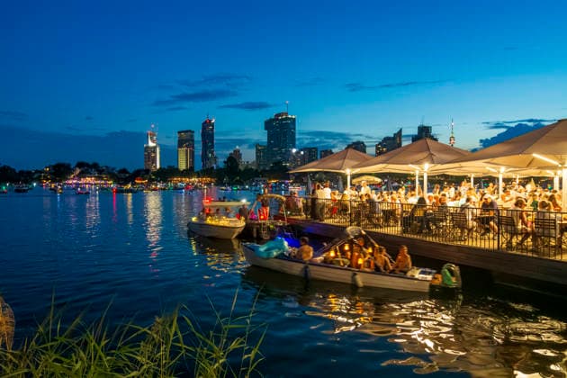 Lichterlfest (Lichterfest, Festival of Lights) at oxbow lake Alte Donau (Old Danube), illuminated boats, high-rises of Donaucity, floating restaurant Strandcafe Vienna 22. Donaustadt Wien Austria