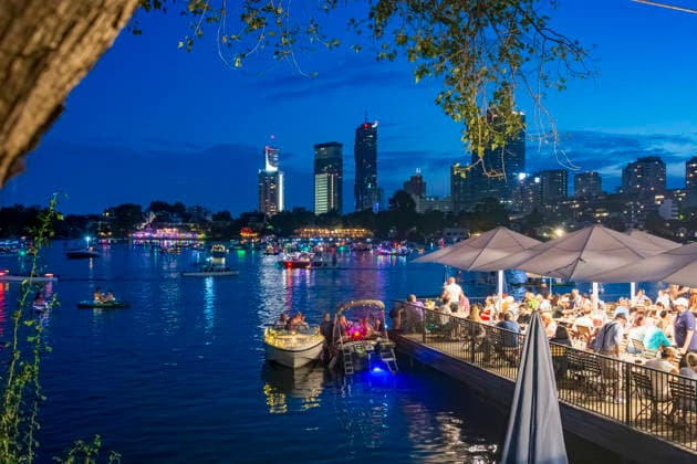 Lichterlfest (Lichterfest, Festival of Lights) at oxbow lake Alte Donau (Old Danube), illuminated boats, high-rises of Donaucity, floating restaurant Strandcafe Vienna 22. Donaustadt Wien Austria