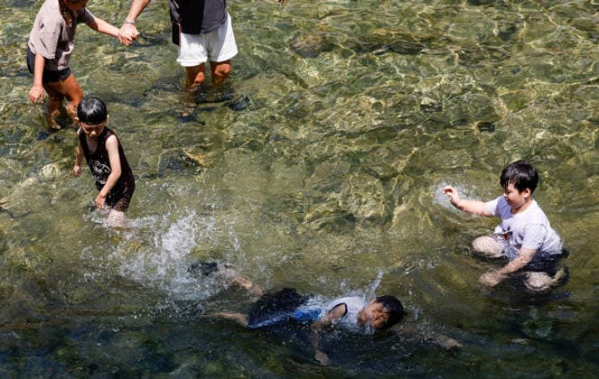 (260802) -- SEOUL, Aug. 2, 2026 -- Children play at the Cheonggye stream to cool off amid a heatwave in Seoul, South Korea, Aug. 2, 2026. (Photo by Xinhua) SOUTH KOREA-HEATWAVE-COOLING OFF JunxHyosang 