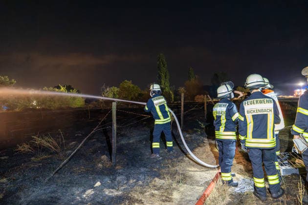 Großer Flächenbrand bedroht Wohngebiet Am 03.08.2026 gegen 02:00 Uhr brannten zwischen Seeheim-Jugenheim und Alsbach im Landkreis Darmstadt-Dieburg rund 28.000 Quadratmeter Feld und Gestrüpp entlang der L3100. Die Feuerwehr stoppte die Flammen etwa fünf Meter vor angrenzenden Wohnhäusern. Ein Anwohner erlitt beim eigenständigen Löschversuch eine Rauchgasvergiftung und wurde vom Rettungsdienst in ein Krankenhaus gebracht. Die Straßenbahnstrecke zwischen Alsbach und Seeheim-Jugenheim wurde gesperrt, ein Schienenersatzverkehr eingerichtet. Zur Brandbekämpfung kam eine Drohne mit Wärmebildkamera zum Aufspüren von Glutnestern zum Einsatz. Seeheim-Jugenheim Hessen Deutschland *** Large Wildfire Threatens Residential Area On August 3,