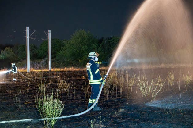 Großer Flächenbrand bedroht Wohngebiet Am 03.08.2026 gegen 02:00 Uhr brannten zwischen Seeheim-Jugenheim und Alsbach im Landkreis Darmstadt-Dieburg rund 28.000 Quadratmeter Feld und Gestrüpp entlang der L3100. Die Feuerwehr stoppte die Flammen etwa fünf Meter vor angrenzenden Wohnhäusern. Ein Anwohner erlitt beim eigenständigen Löschversuch eine Rauchgasvergiftung und wurde vom Rettungsdienst in ein Krankenhaus gebracht. Die Straßenbahnstrecke zwischen Alsbach und Seeheim-Jugenheim wurde gesperrt, ein Schienenersatzverkehr eingerichtet. Zur Brandbekämpfung kam eine Drohne mit Wärmebildkamera zum Aufspüren von Glutnestern zum Einsatz. Seeheim-Jugenheim Hessen Deutschland *** Large Wildfire Threatens Residential Area On August 3,