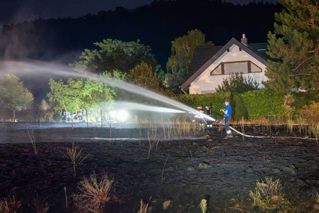 Großer Flächenbrand bedroht Wohngebiet Am 03.08.2026 gegen 02:00 Uhr brannten zwischen Seeheim-Jugenheim und Alsbach im Landkreis Darmstadt-Dieburg rund 28.000 Quadratmeter Feld und Gestrüpp entlang der L3100. Die Feuerwehr stoppte die Flammen etwa fünf Meter vor angrenzenden Wohnhäusern. Ein Anwohner erlitt beim eigenständigen Löschversuch eine Rauchgasvergiftung und wurde vom Rettungsdienst in ein Krankenhaus gebracht. Die Straßenbahnstrecke zwischen Alsbach und Seeheim-Jugenheim wurde gesperrt, ein Schienenersatzverkehr eingerichtet. Zur Brandbekämpfung kam eine Drohne mit Wärmebildkamera zum Aufspüren von Glutnestern zum Einsatz. Seeheim-Jugenheim Hessen Deutschland *** Large Wildfire Threatens Residential Area On August 3,