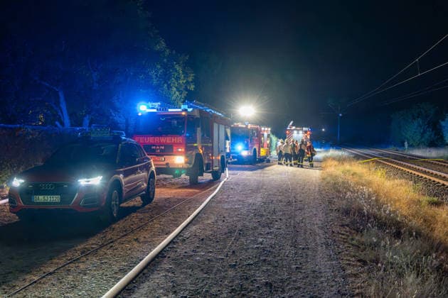 Großer Flächenbrand bedroht Wohngebiet Am 03.08.2026 gegen 02:00 Uhr brannten zwischen Seeheim-Jugenheim und Alsbach im Landkreis Darmstadt-Dieburg rund 28.000 Quadratmeter Feld und Gestrüpp entlang der L3100. Die Feuerwehr stoppte die Flammen etwa fünf Meter vor angrenzenden Wohnhäusern. Ein Anwohner erlitt beim eigenständigen Löschversuch eine Rauchgasvergiftung und wurde vom Rettungsdienst in ein Krankenhaus gebracht. Die Straßenbahnstrecke zwischen Alsbach und Seeheim-Jugenheim wurde gesperrt, ein Schienenersatzverkehr eingerichtet. Zur Brandbekämpfung kam eine Drohne mit Wärmebildkamera zum Aufspüren von Glutnestern zum Einsatz. Seeheim-Jugenheim Hessen Deutschland *** Large Wildfire Threatens Residential Area On August 3,